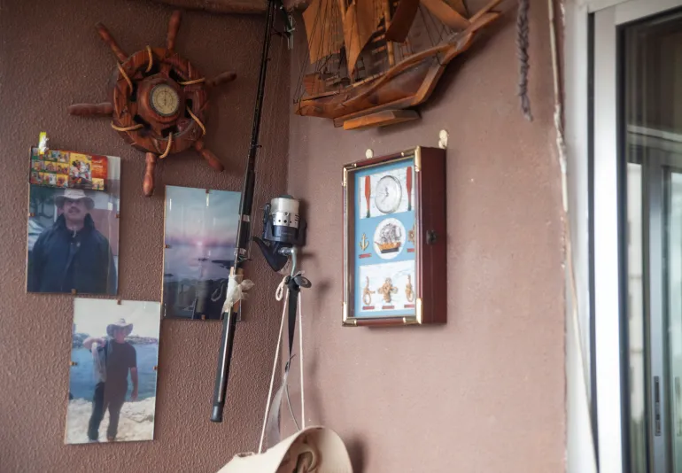 A corner of the balcony of Chadi's parents' apartment contains objects and photos from Sabah's time as a fisherman [Tessa Fox/Al Jazeera]